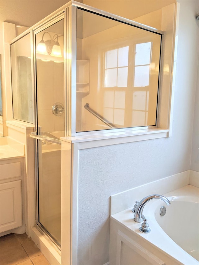 bathroom with tile patterned floors, vanity, and shower with separate bathtub