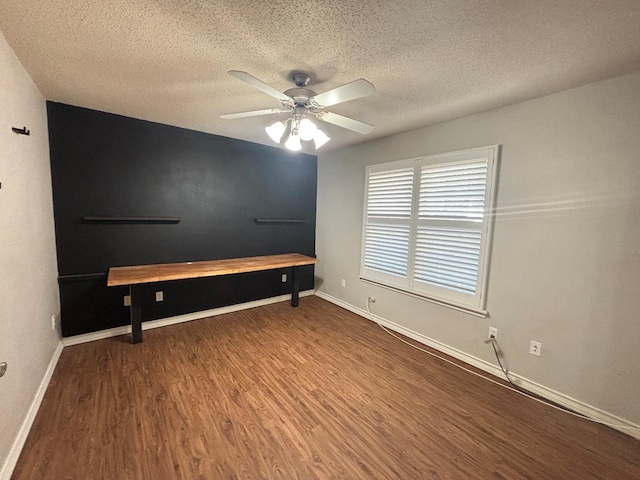 interior space with ceiling fan, wood-type flooring, and a textured ceiling