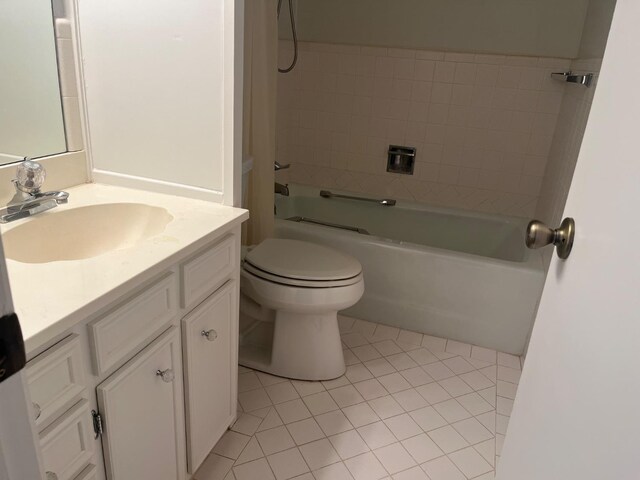 full bathroom with tiled shower / bath, vanity, toilet, and tile patterned floors