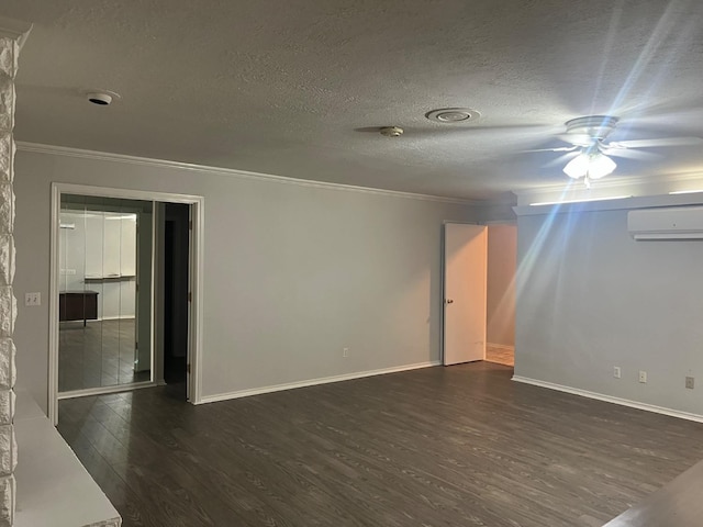 spare room featuring dark hardwood / wood-style floors, a wall mounted AC, ornamental molding, ceiling fan, and a textured ceiling