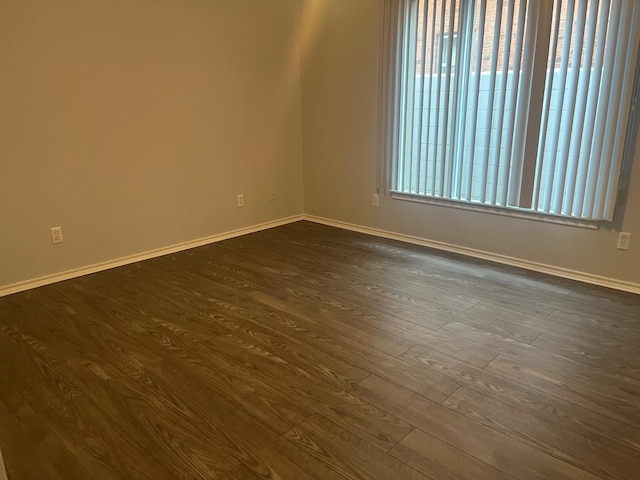 unfurnished room featuring a healthy amount of sunlight and dark hardwood / wood-style flooring