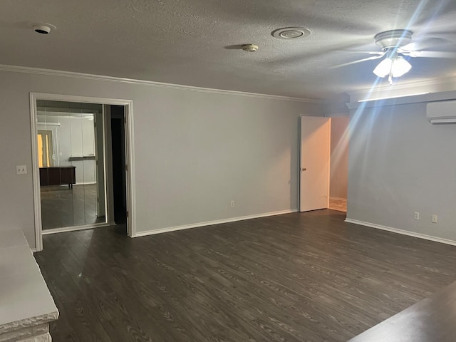 empty room featuring ornamental molding, dark hardwood / wood-style flooring, a textured ceiling, and an AC wall unit