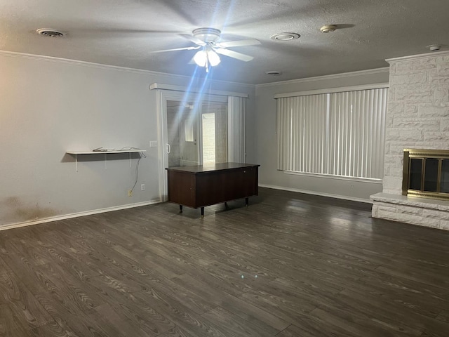 unfurnished living room featuring dark hardwood / wood-style floors, a fireplace, ceiling fan, crown molding, and a textured ceiling