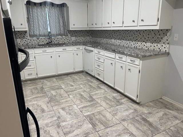 kitchen with stainless steel fridge, sink, and white cabinets