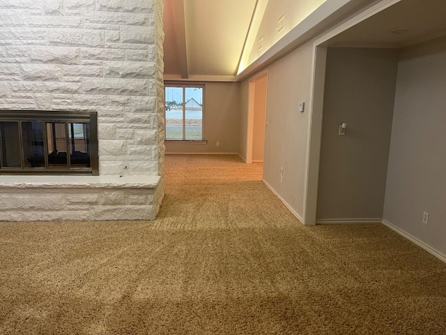 unfurnished living room featuring a stone fireplace and carpet floors