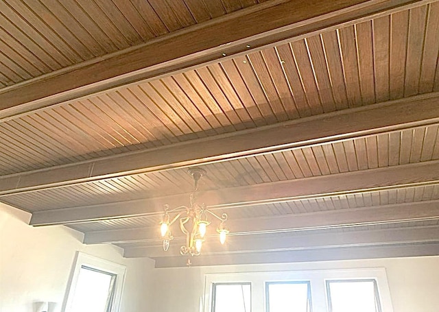 interior details featuring beam ceiling and a chandelier