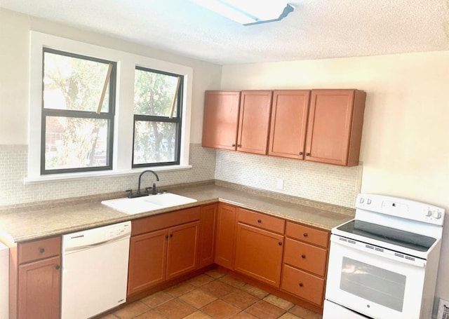 kitchen with tasteful backsplash, sink, a textured ceiling, and white appliances