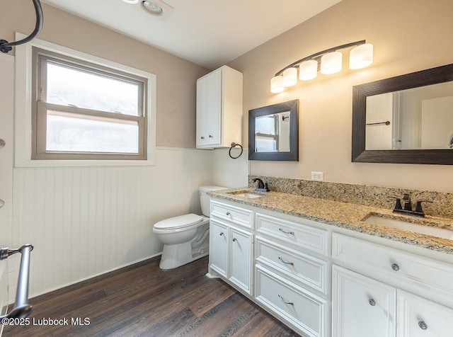3423 60th St, Lubbock, TX 79413 - bathroom with wood finished floors, double vanity, and a wainscoted wall