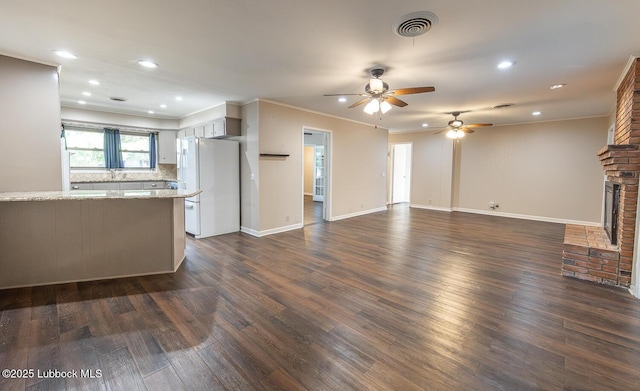 3423 60th St, Lubbock, TX 79413 - unfurnished living room with ceiling fan, dark wood-style flooring, recessed lighting, a fireplace, and crown molding