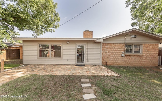 3423 60th St, Lubbock, TX 79413 - back of house featuring a chimney, a patio, and brick siding