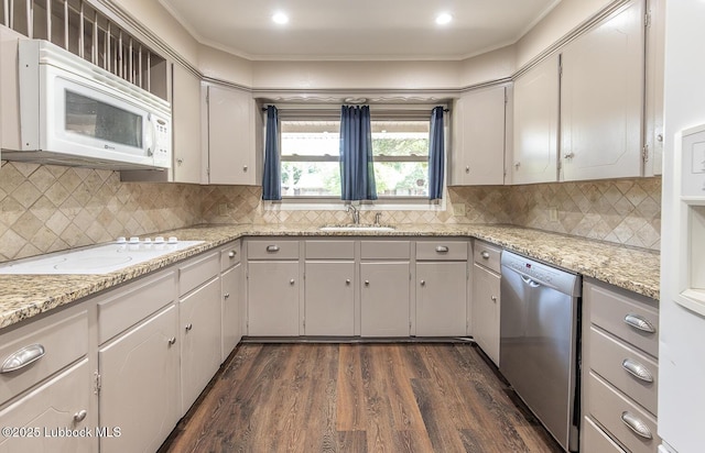 3423 60th St, Lubbock, TX 79413 - kitchen with white appliances, dark wood-style floors, decorative backsplash, ornamental molding, and light stone countertops