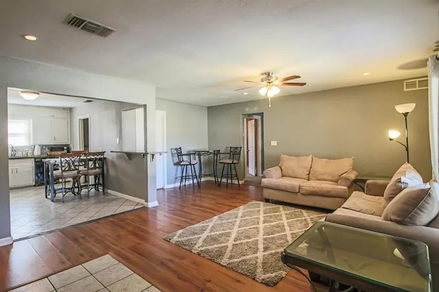 living room featuring sink, light hardwood / wood-style floors, and ceiling fan