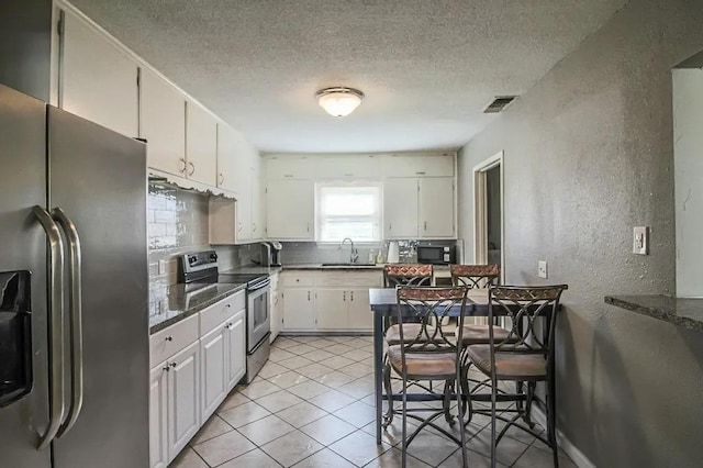 kitchen featuring tasteful backsplash, appliances with stainless steel finishes, sink, and white cabinets