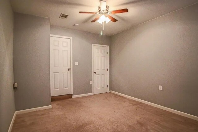 unfurnished room with ceiling fan and carpet flooring