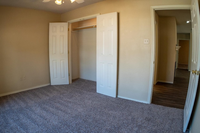 unfurnished bedroom with ceiling fan, dark carpet, and a closet