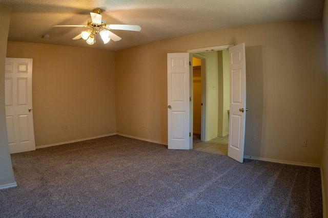 unfurnished bedroom with a textured ceiling, light colored carpet, and ceiling fan