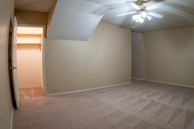 additional living space featuring ceiling fan, vaulted ceiling, and light carpet