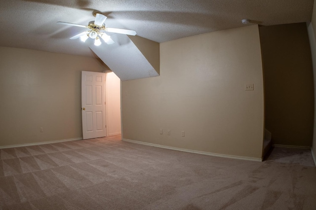 bonus room with light colored carpet, a textured ceiling, and ceiling fan