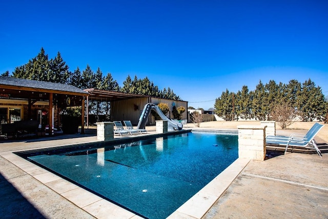 view of pool with a water slide and a patio area