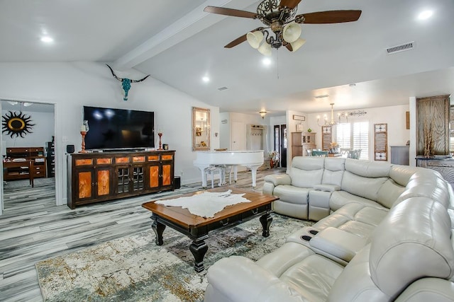 living room featuring ceiling fan with notable chandelier, lofted ceiling with beams, and light wood-type flooring