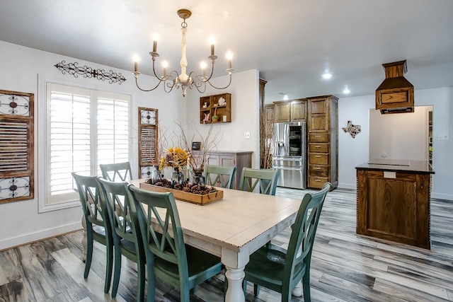 dining space with light hardwood / wood-style flooring and a chandelier