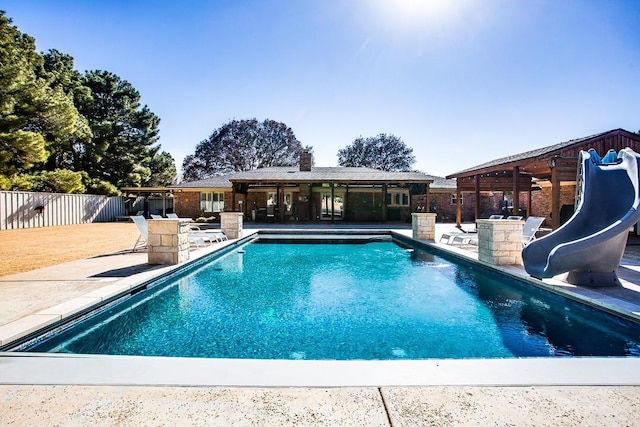 view of pool featuring a water slide and a patio area