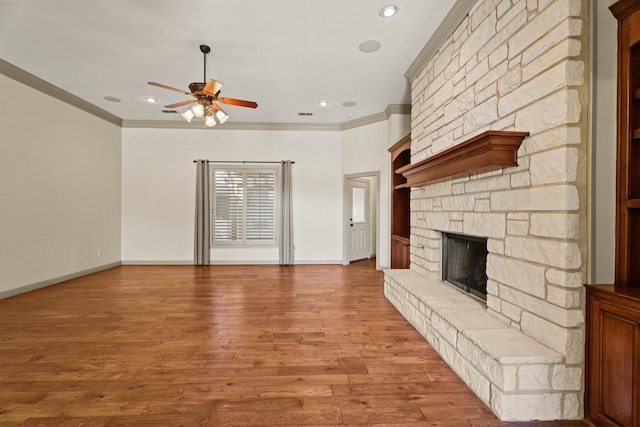 unfurnished living room with recessed lighting, a stone fireplace, baseboards, a ceiling fan, and crown molding