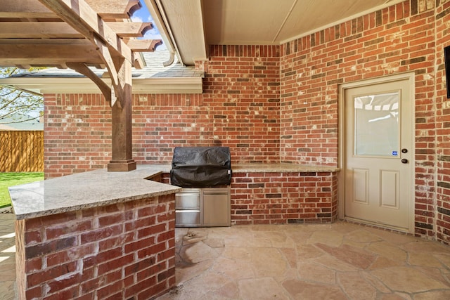 view of patio / terrace with a grill and fence