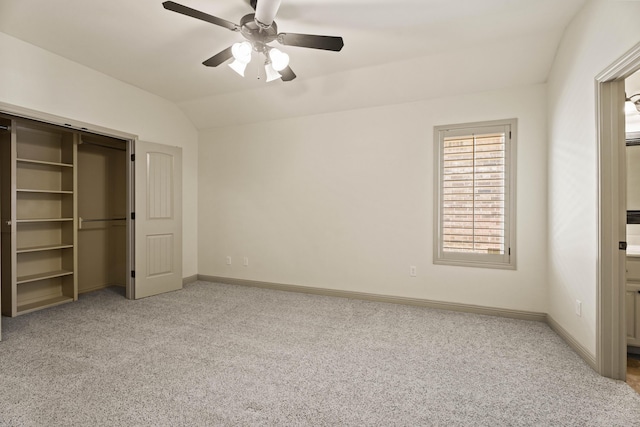 unfurnished bedroom with baseboards, light carpet, a closet, and lofted ceiling
