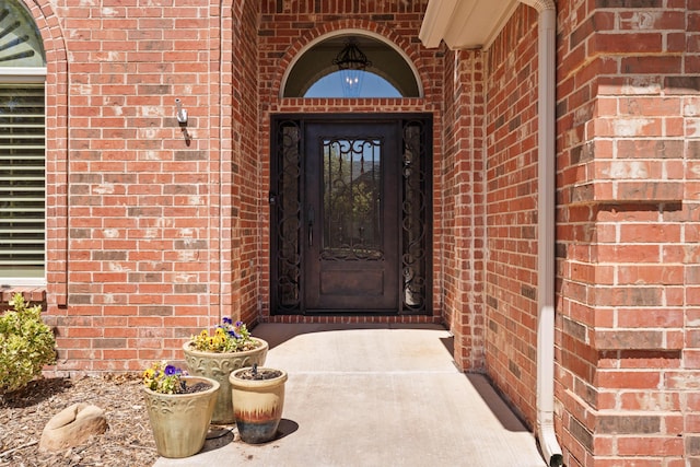 property entrance featuring brick siding