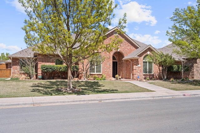 view of front of property with a front yard and brick siding