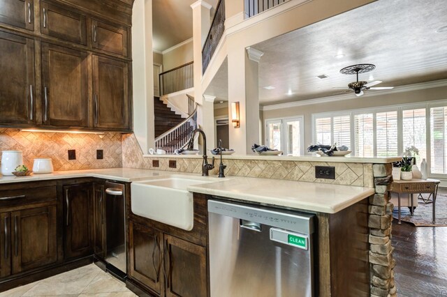 kitchen featuring sink, dark brown cabinets, ornamental molding, dishwasher, and kitchen peninsula