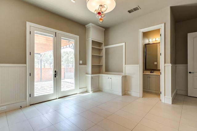 doorway to outside featuring light tile patterned flooring and french doors