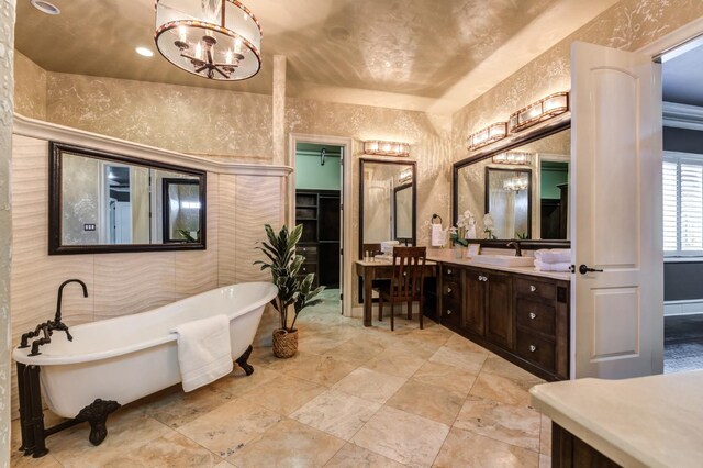 bathroom with vanity, a washtub, a notable chandelier, and tile walls