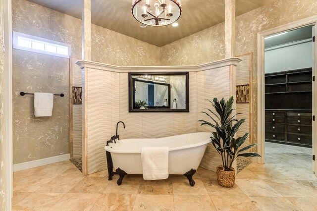 bathroom featuring a washtub and a chandelier