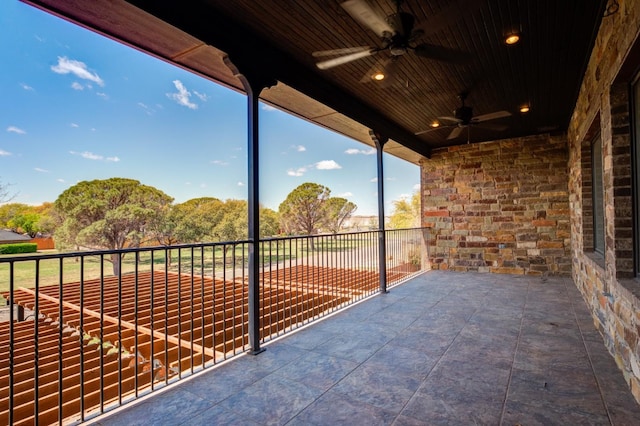 view of patio with ceiling fan and a balcony