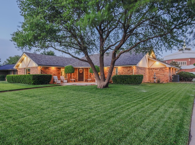 6109 Elkhart Ave, Lubbock, TX 79424 - view of front of house with a front yard, brick siding, and a shingled roof