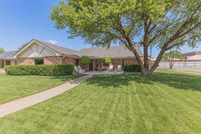 6109 Elkhart Ave, Lubbock, TX 79424 - ranch-style house featuring a front yard, brick siding, and a shingled roof