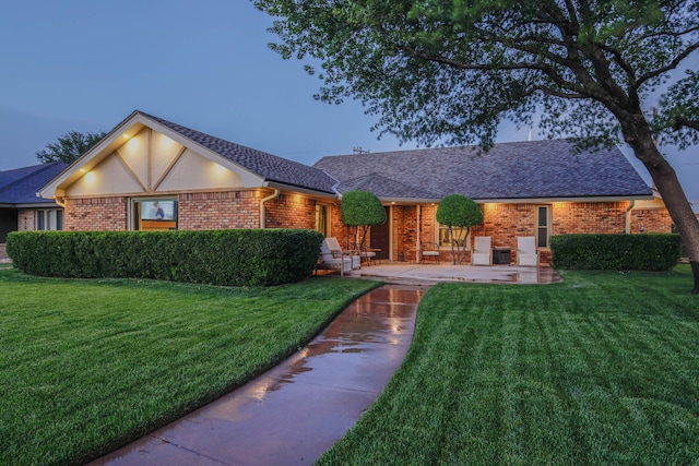 6109 Elkhart Ave, Lubbock, TX 79424 - view of front of property featuring a front yard, brick siding, and a shingled roof