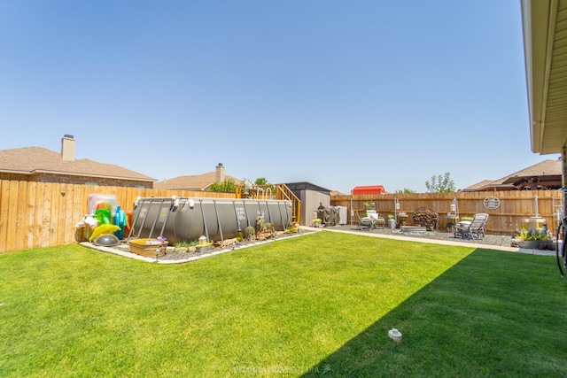 view of yard with a fenced in pool and a patio