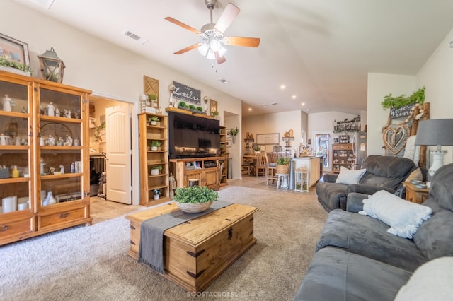 carpeted living room featuring ceiling fan and vaulted ceiling