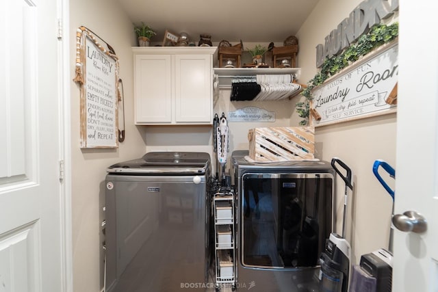 clothes washing area featuring cabinets and washing machine and clothes dryer