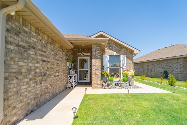 property entrance with a yard and a patio area