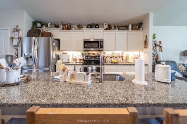 kitchen with light stone countertops, white cabinets, and appliances with stainless steel finishes