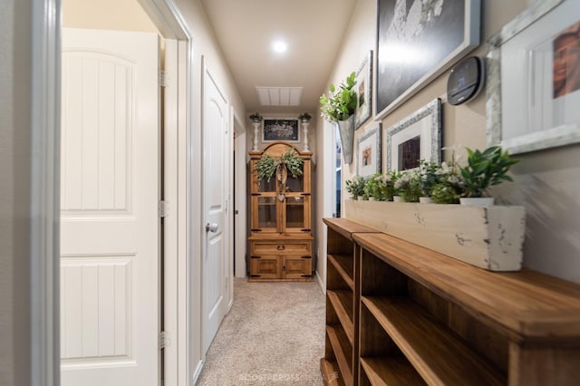 corridor featuring light colored carpet