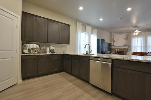 kitchen featuring dark brown cabinetry, sink, light stone counters, light hardwood / wood-style flooring, and stainless steel dishwasher