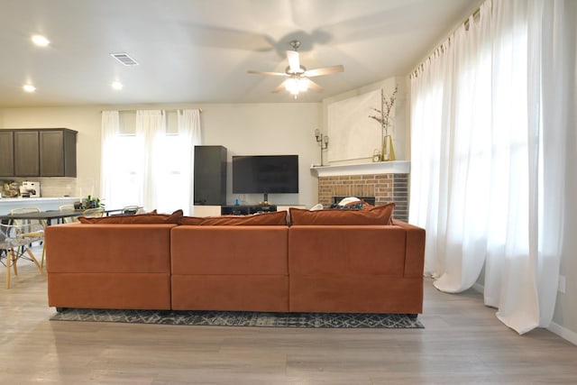 living room featuring ceiling fan, a healthy amount of sunlight, and light hardwood / wood-style floors