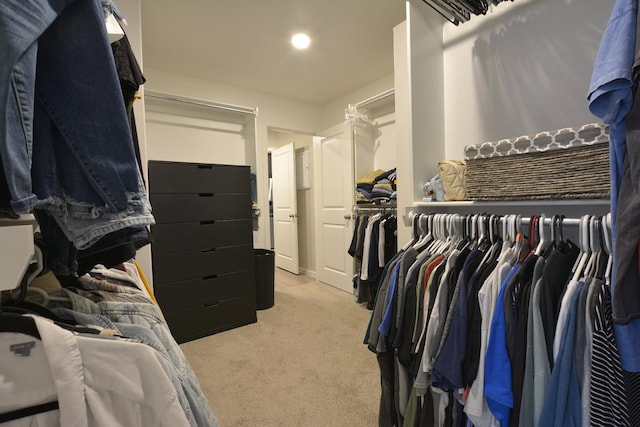 walk in closet with light carpet