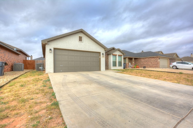 ranch-style house featuring a garage, cooling unit, and a front lawn