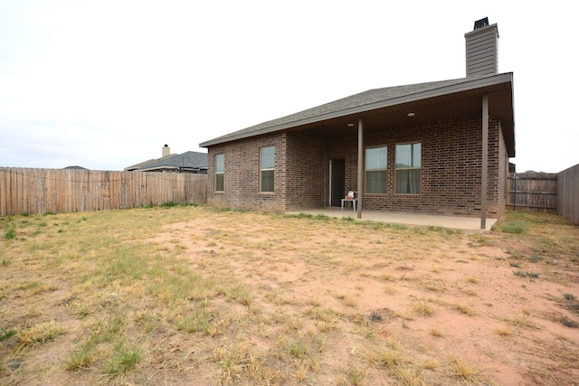 rear view of house with a patio area and a lawn